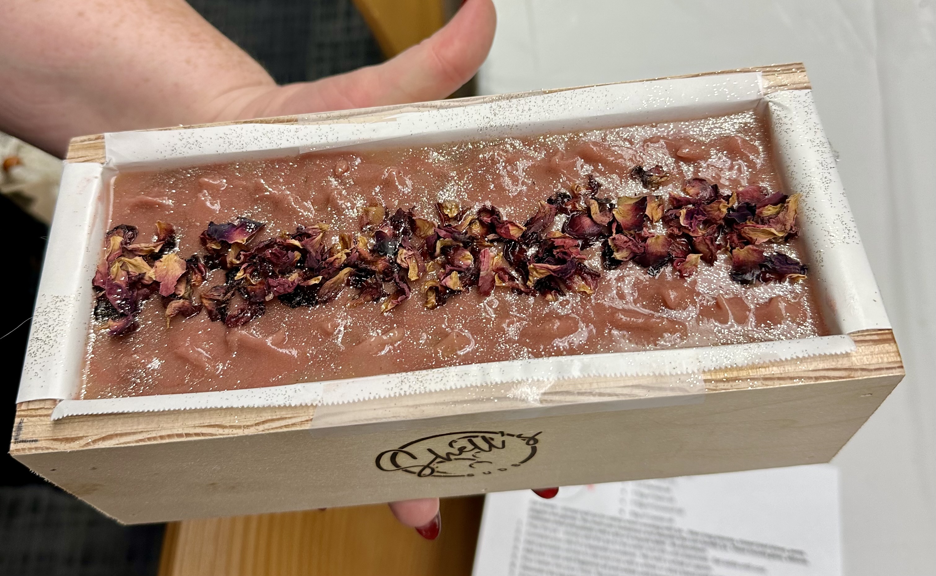 A soap loaf topped with dried rose petals